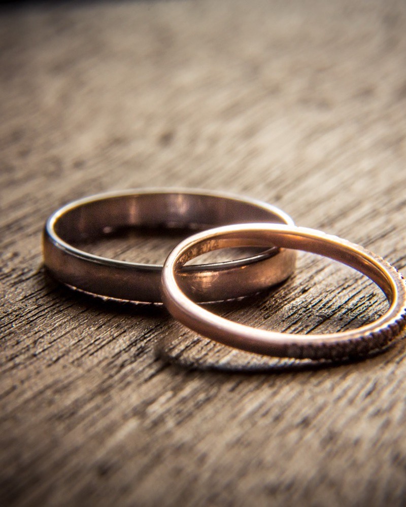 Les alliances des mariés posées sur un bois patiné — galerie photo de mariage